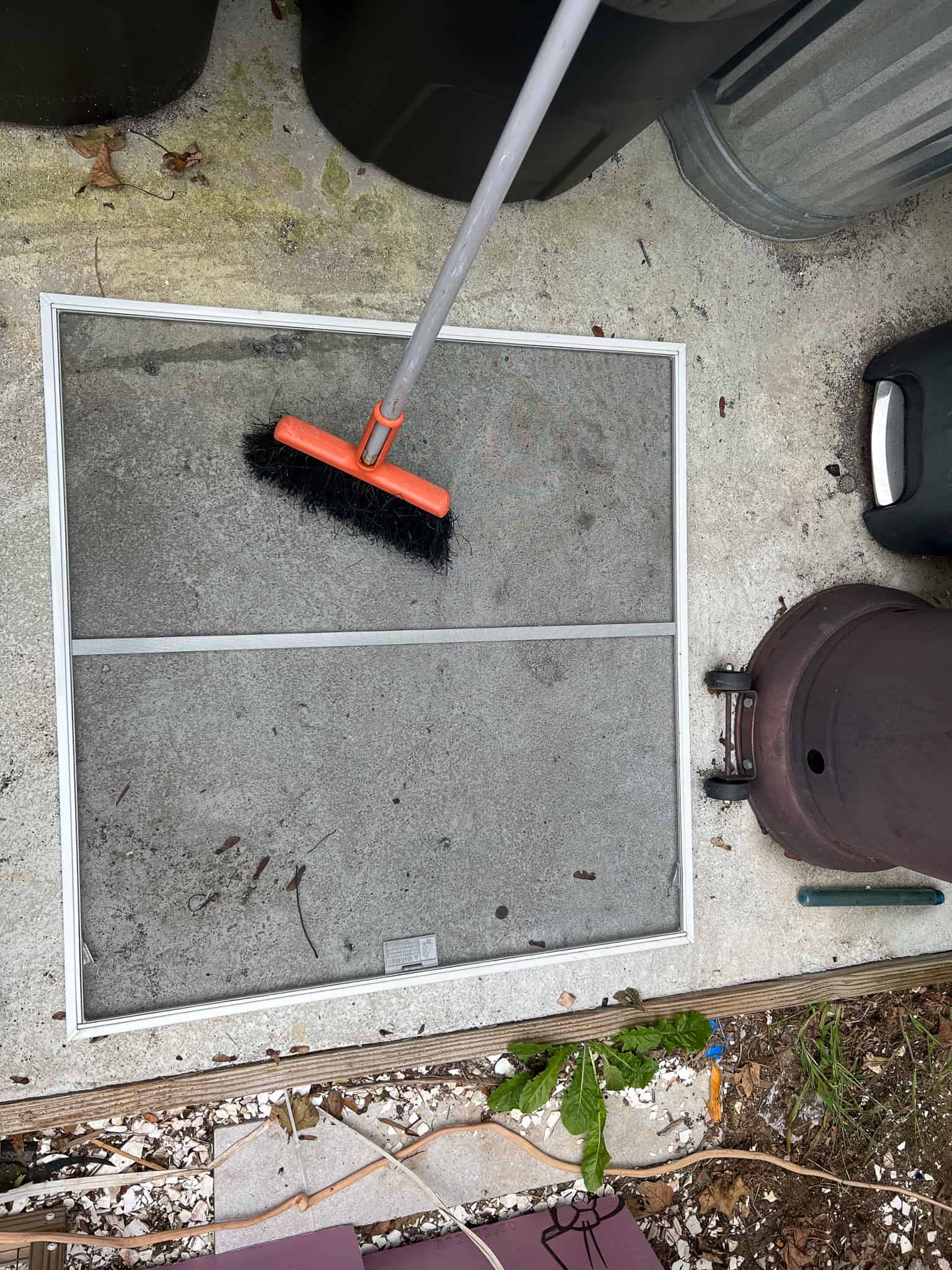 cleaning window screen with broom