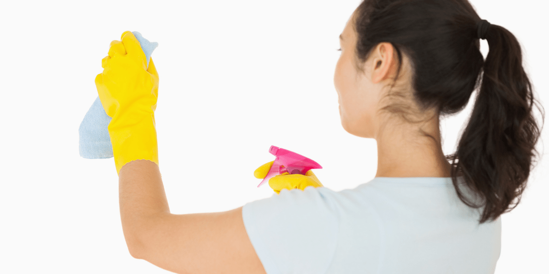 woman cleaning wall with vinegar