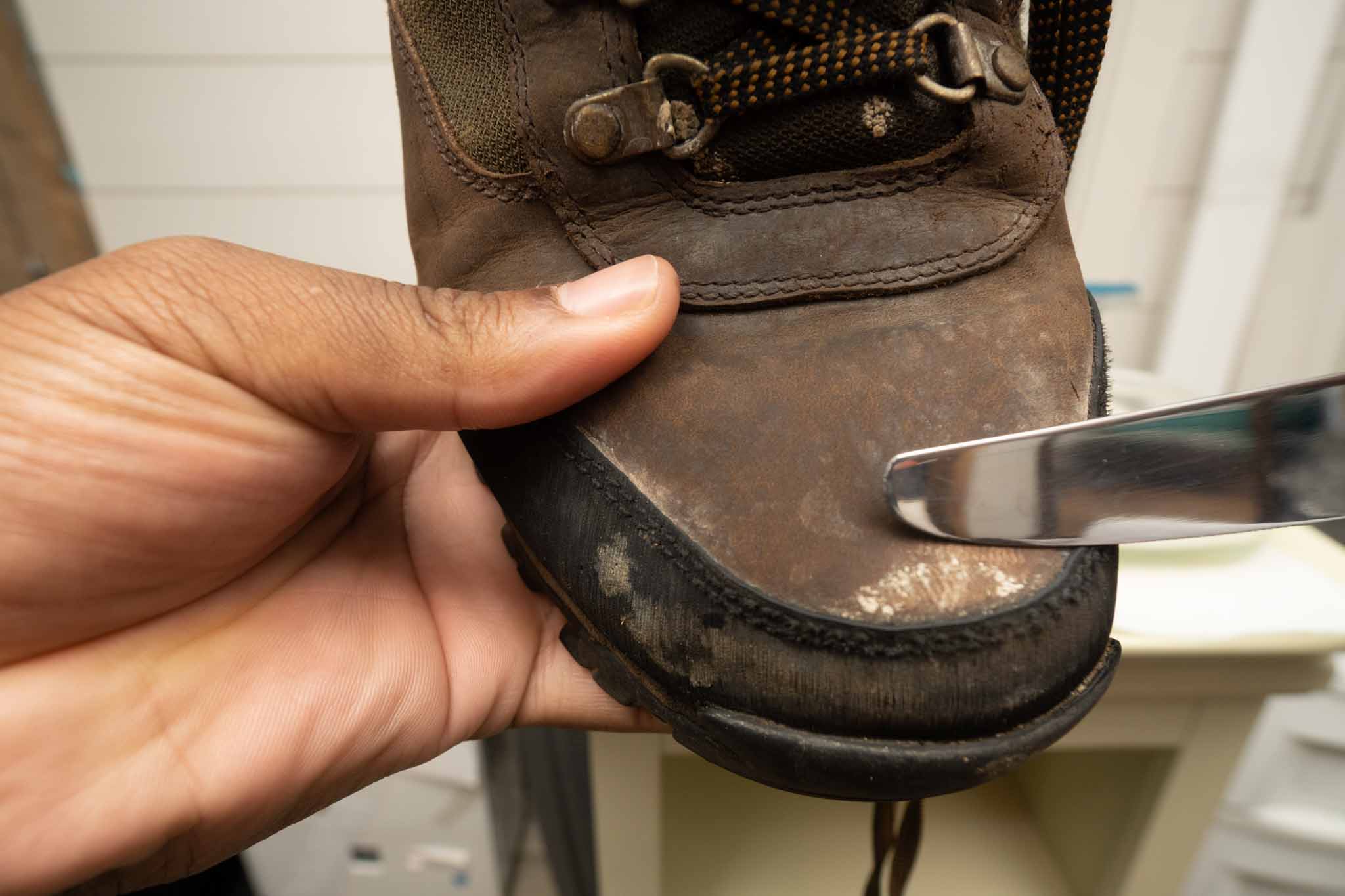 using butter knife to clean work boots