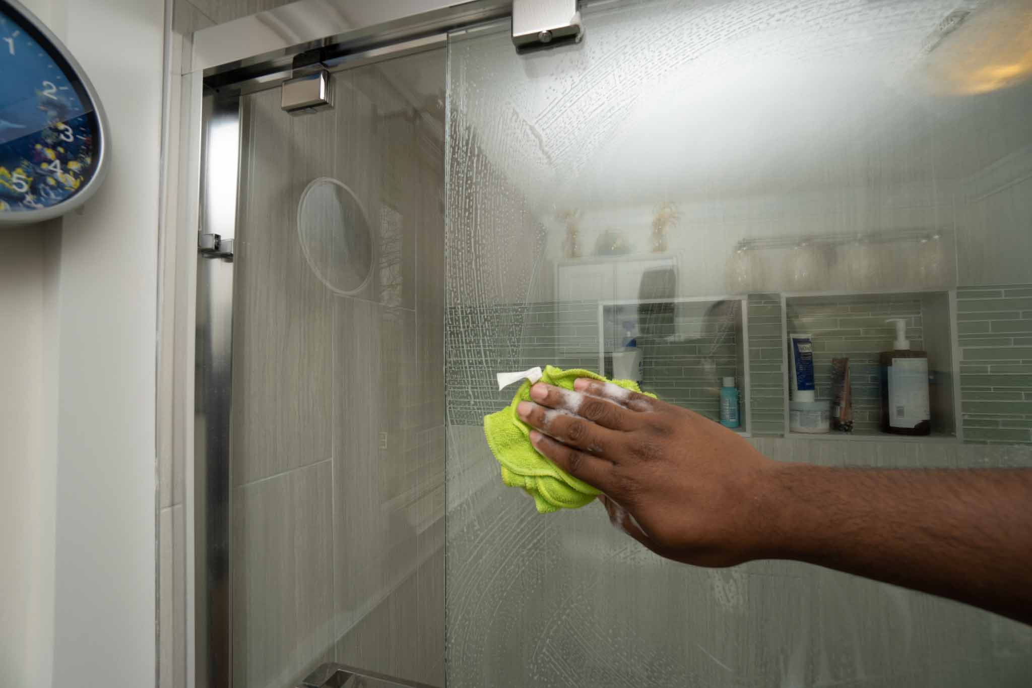using microfiber cloth to clean shower glass