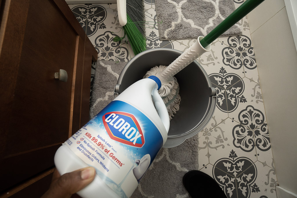 pouring bleach in cleaning bucket