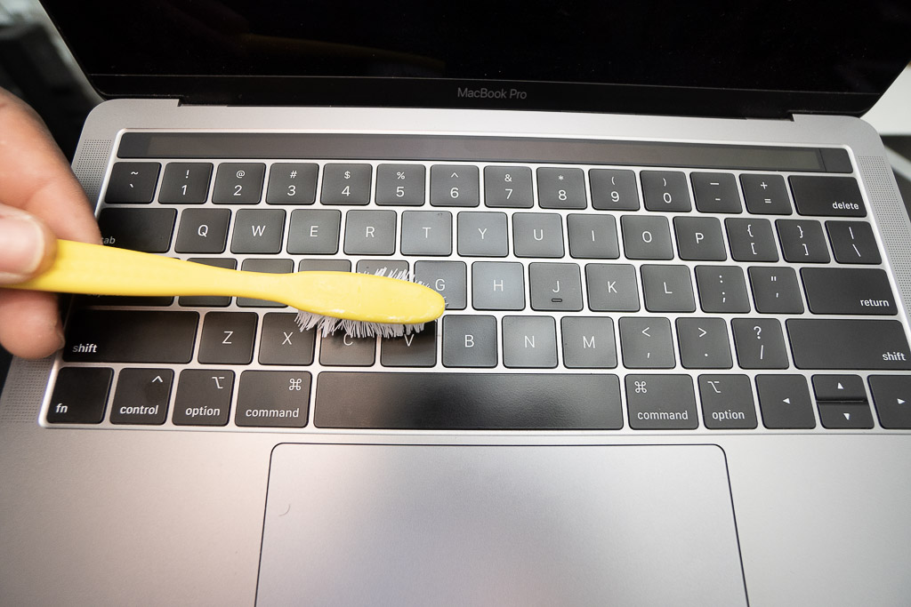 cleaning keyboard with toothbrush