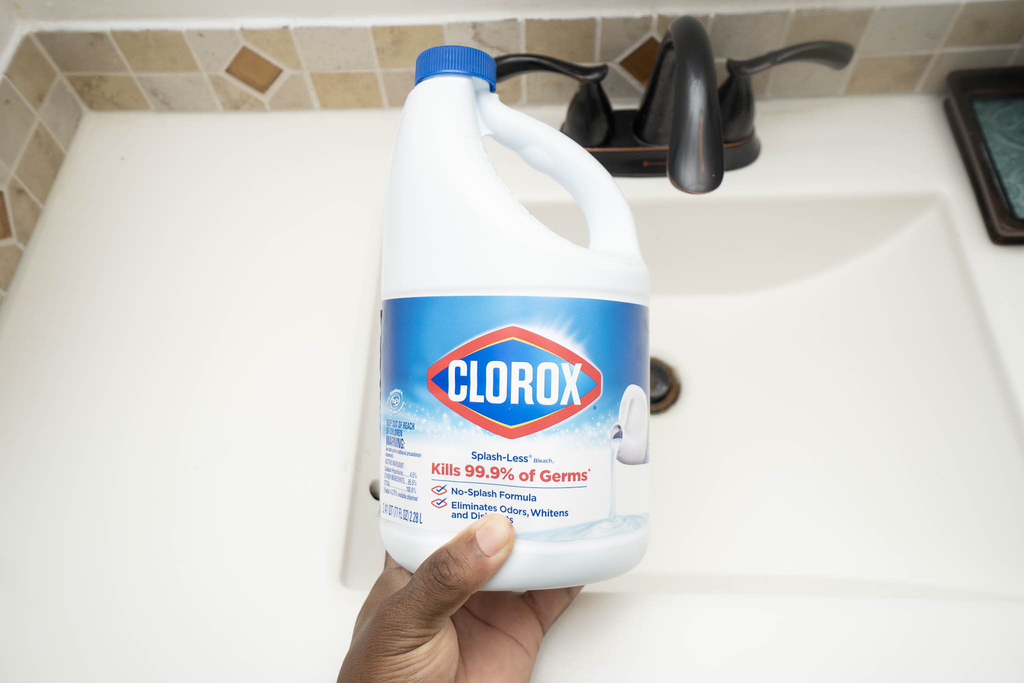holding clorox bleach in hand