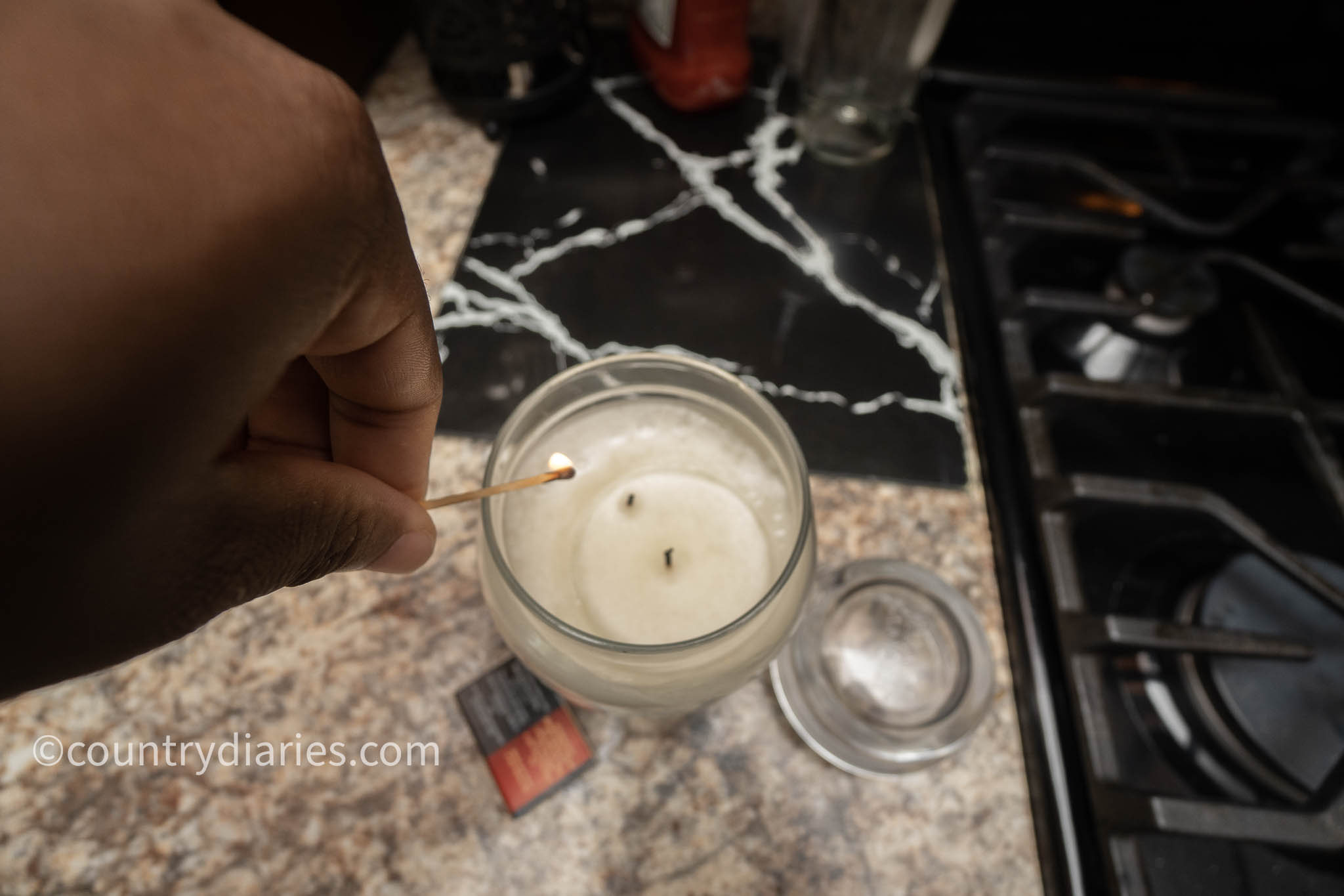 Person lighting candle with match