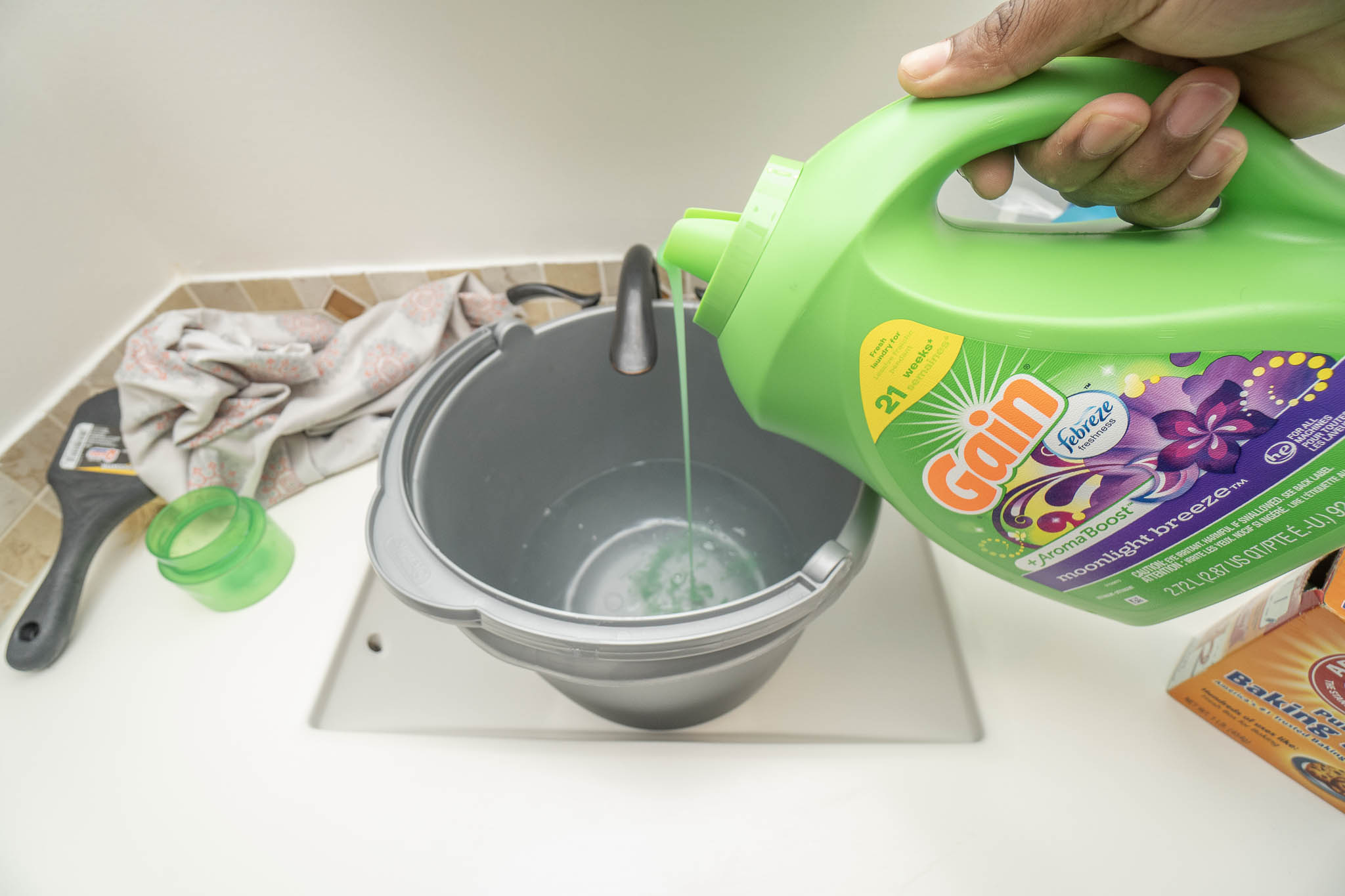 adding laundry detergent to water